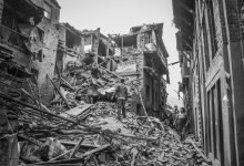 people looking at wrecked buildings